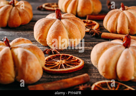 Torte fatte in casa a forma di zucca scuro su sfondo di legno Foto Stock