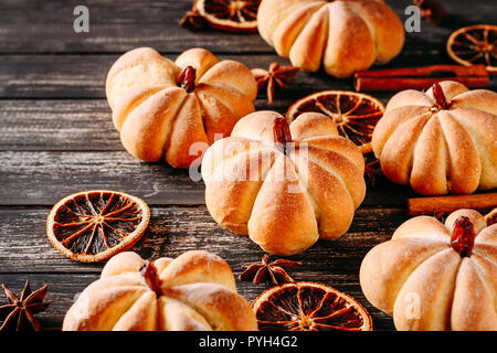 Torte fatte in casa a forma di zucca scuro su sfondo di legno Foto Stock