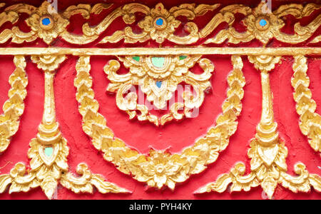 Tailandese tradizionale modello di stucco dorato che decorata con la parete della chiesa nel tempio thailandese Foto Stock