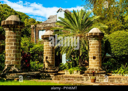 Il restaurato pece e catrame store, ora l'Admirals Inn sorge mascherata da alberi dietro il boat house e veleria pilastri, Nelson's Dockyard, Antigua Foto Stock