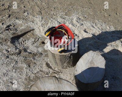 Casco di sicurezza sul log sulla spiaggia Foto Stock