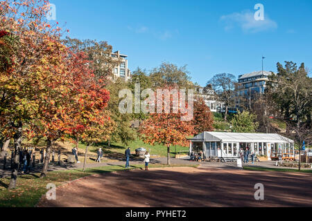 Alberi con colori autunnali a ovest di Princes Street Gardens Edinburgh Scotland Regno Unito con cafe a destra Foto Stock