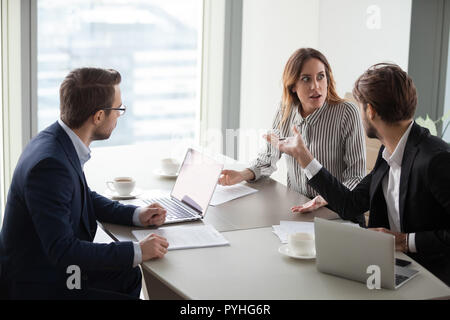 Angry Man accusando il collega di sesso femminile, intern, rimproverando per errore Foto Stock