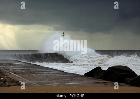 Onda pier e faro di Ave foce, a nord del Portogallo, la prima pioggia e grande tempesta Foto Stock