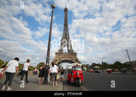 Parigi, Ile-de-France, Francia - i turisti uno stand alla autorickshaw sul Pont d'Iéna bridge e sullo sfondo la torre Eiffel - il principale punto di riferimento della capitale francese. Foto Stock