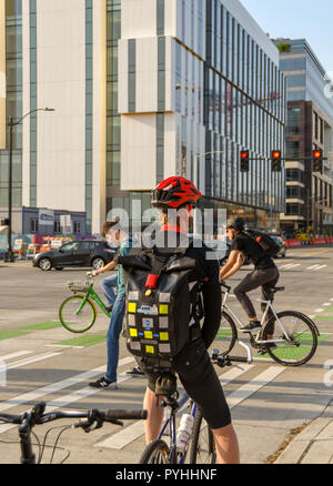 SEATTLE, NELLO STATO DI WASHINGTON, STATI UNITI D'AMERICA - Giugno 2018: ciclista pendolarismo per lavorare a Seattle in attesa in corrispondenza di un incrocio stradale. Foto Stock