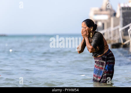 Indiano donna Indù facendo un tuffo nel santo Gomti fiume presso la città di Dwarka, Gujarat, India Foto Stock