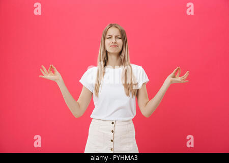 Blonde beauiful giovane femmina fa mudra segno, si rilassa dopo la dura giornata lavorativa, continua a chiudere gli occhi, le pratiche yoga contro sfondo rosa. Giovane donna graziosa medita indoor. Concetto di rilassamento. Foto Stock