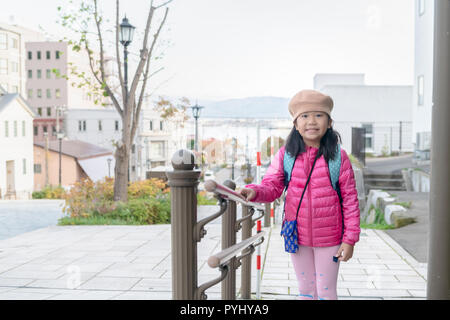 Ritratto di Cute girl pink usura down jacket in hakodate Harbour View, concetto di viaggio Foto Stock