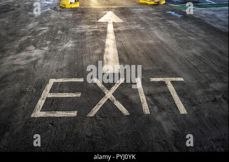 Uscita freccia e verniciate sul pavimento di una multi-storia car park, concept Foto Stock