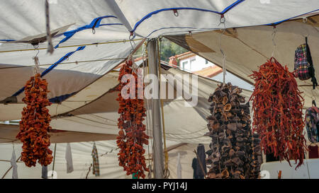 Peperoncino, la cannella e i pomodori seccati al sole appeso sopra un mercato turco in stallo sulle stringhe Foto Stock