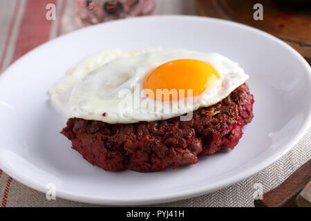 Svedese hamburger di manzo Biff a la Lindstrom con uovo fritto Foto Stock