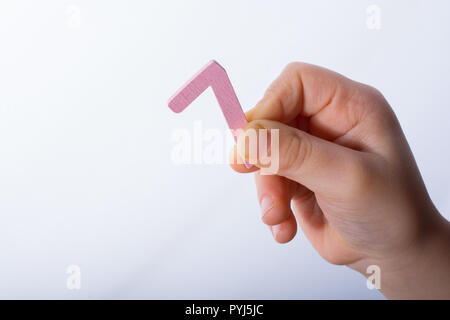 Numero 7 sette di legno nella mano di un bambino Foto Stock