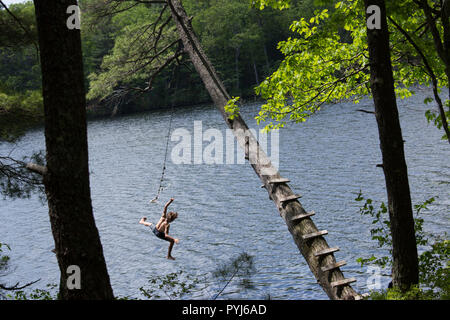 Oscillazione su una corda swing, in un caldo giorno d'estate. Foto Stock