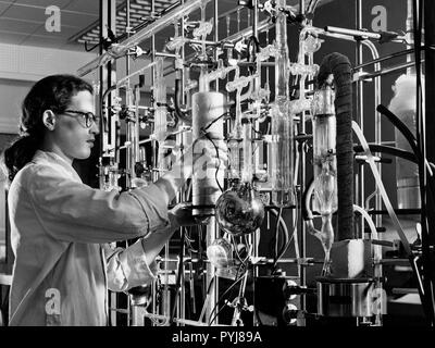 Materiali di un ricercatore presso il NACA Lewis volo laboratorio di propulsione esamina una cricca superficiale apparecchiatura di rilevazione di materiali e di costruzione di sollecitazioni durante il mese di dicembre 1952. Foto Stock