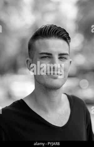 Bianco e nero ritratto di Giovane uomo bello all'aperto Foto Stock