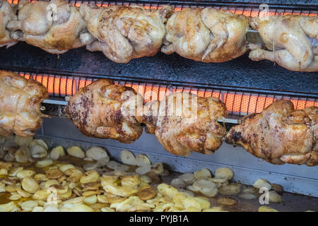 Pollo,polli,essendo,,arrosto con,chips,patate,essendo,cotto,fritto,a,gocciolamento,succhi di frutta, succhi di frutta,Esperaza,Domenica,mercato,Aude,sud,d,Francia,francese,cibo Foto Stock