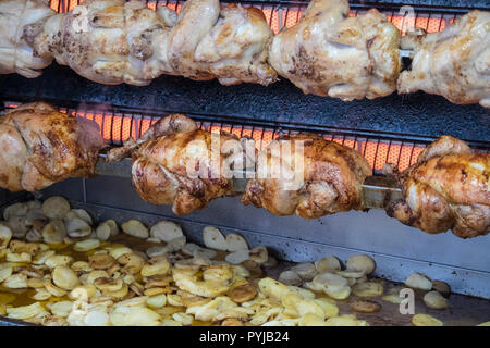 Pollo,polli,essendo,,arrosto con,chips,patate,essendo,cotto,fritto,a,gocciolamento,succhi di frutta, succhi di frutta,Esperaza,Domenica,mercato,Aude,sud,d,Francia,francese,cibo Foto Stock