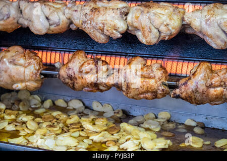 Pollo,polli,essendo,,arrosto con,chips,patate,essendo,cotto,fritto,a,gocciolamento,succhi di frutta, succhi di frutta,Esperaza,Domenica,mercato,Aude,sud,d,Francia,francese,cibo Foto Stock