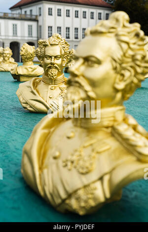 Sculture dorate che mostra la testa di re Ludwig II dell'arte di installazione da Ottmar Hörl nel parco del castello di Nymphenburg a Monaco di Baviera Foto Stock