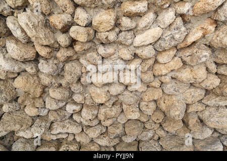 Antico muro fatto di pietre rotonde come sfondo o uno sfondo Foto Stock