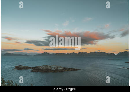 Alba e tramonto a Henningsvaer oltre oceano Atlantico con nuvole rosa. Il villaggio di pescatori situato su numerose piccole isole Lofoten archipela Foto Stock