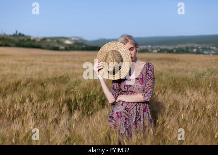 Una contadina in un campo di grano maturo e la segala Foto Stock