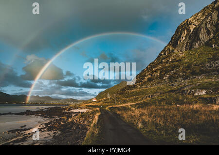 Arcobaleno doppio sopra il piccolo villaggio di pescatori con il blu del cielo e cloouds e montagne delle isole Lofoten in Norvegia. Foto scattata in Norvegia. Foto Stock