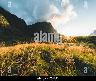 Tradizionale in rosso fishin casa in Bjoernsand vicino a Reine in Lofoten, Norvegia con red rorbu case. Pomeriggio al Tramonto con le nuvole su di una spiaggia di sabbia. Foto t Foto Stock