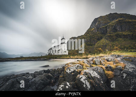 Lunga esposizione della chiesa bianca di Gimsoy con rocce e oceano atlantico. Foto scattata sul isola di Gimsoy, Lofoten in Norvegia. Foto scattata in Norvegia. Foto Stock