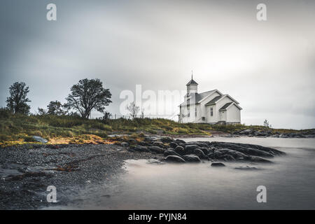 Lunga esposizione della chiesa bianca di Gimsoy con rocce e oceano atlantico. Foto scattata sul isola di Gimsoy, Lofoten in Norvegia. Foto scattata in Norvegia. Foto Stock