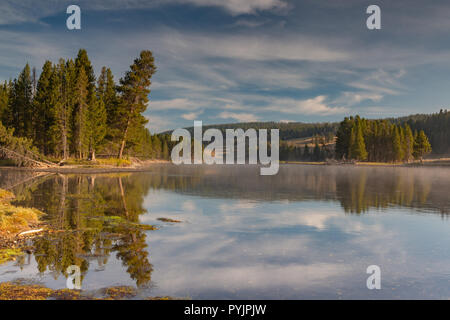 Yellowstone River su una ca;m morining con riflessioni degli alberi su una bella cascata di sky giorno. Foto Stock