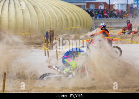 Weymouth Dorset, Regno Unito. Il 28 ottobre 2018. Molto freddo e ventoso giorno per la gara di motocross sulla spiaggia di Weymouth, come il vento soffia la sabbia dappertutto. Oltre 300 biciclette a prendere parte e migliaia a sua volta guarda cercando di evitare la sabbia sempre nei loro occhi! Credito: Carolyn Jenkins/Alamy Live News Foto Stock