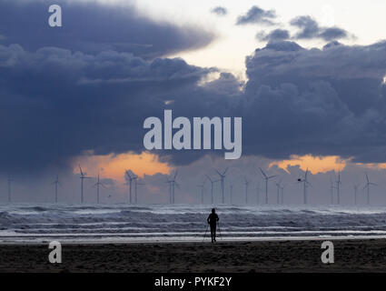 Seaton Carew, County Durham, Inghilterra, Regno Unito. 29 ott 2018. Meteo: un ardito walker sotto un cielo tempestoso su Seaton Carew a sunrise come grandine sweep di docce in fuori del Mare del Nord su un gelido lunedì mattina sulla costa nord est. Credito: ALAN DAWSON/Alamy Live News Foto Stock