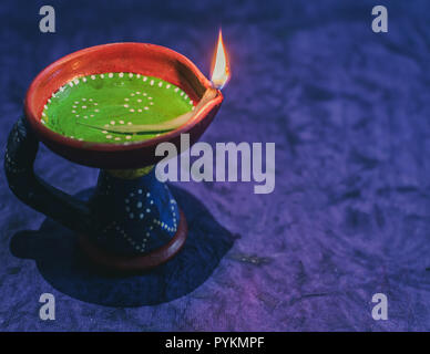 Diwali decorazioni con indiani tradizionali lampade a olio con messa a fuoco selettiva e sfondo giallo. Foto Stock