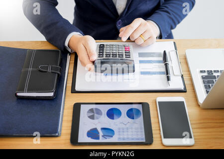 Imprenditore lavoro sulla scrivania office business analisi finanziaria grafici o diagrammi di calcolo contabile bugget denaro prestito fiscale ispettore rendendo relazione. Foto Stock