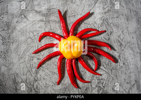 Red hot chili pepper pod vicino - fino sul cemento grigio Sfondo. Messa a fuoco selettiva e spazio di copia Foto Stock