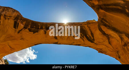 Sun spiata attraverso arco di uranio in Moab Utah Foto Stock