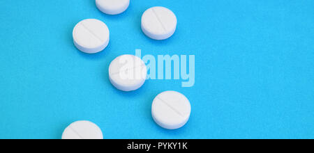 Un paio di compresse bianche giacciono su un blu brillante superficie di sfondo. Immagine di sfondo sul farmaceutico e medico, argomenti Foto Stock