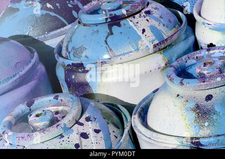 Un sacco di blu usati serbatoi in metallo con vernice per disegnare graffiti Foto Stock