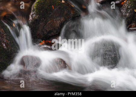 Acqua in movimento su fiume rocce al legno Glengarra Foto Stock