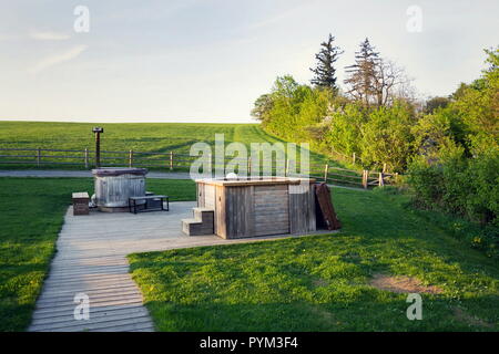 Vasca idromassaggio in legno e vasca calda durante il tramonto in bella estate paesaggio rurale Foto Stock