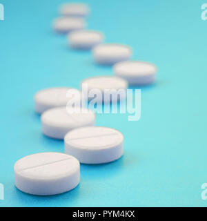 Un paio di compresse bianche giacciono su un blu brillante superficie di sfondo. Immagine di sfondo sul farmaceutico e medico, argomenti Foto Stock