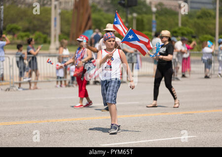 Chicago, Illinois, Stati Uniti d'America - 16 Giugno 2018: Il Puerto Rican Day Parade, Puerto Rican boy sventolando il Puerto Rican bandiera camminare per la strada durante il Foto Stock