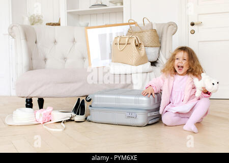 Felice bambina gioca con una valigia rétro Foto Stock