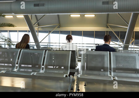 La gente di affari come passeggeri in aeroporto in attesa del volo di coincidenza Foto Stock