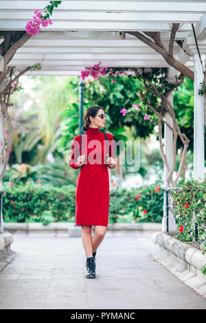 Giovane bella donna in abito rosso in posa di giardino su Gran Canaria Island Foto Stock