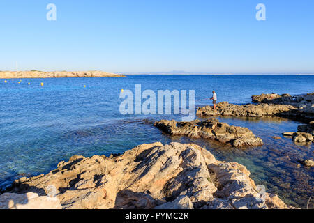 L'uomo solo di pesca in un acqua pulita mare Mallorca, Spagna, acqua di mare pulita Illettes, seascape Foto Stock