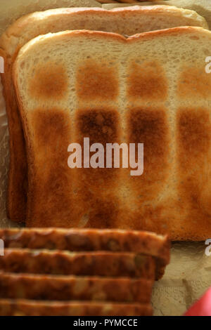 Diversi tipi di pane in un cestino del pane per la colazione o per il tè, marrone leggermente il pane tostato e pane di grano Foto Stock