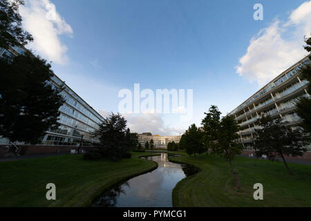 Due alti e lunghi appartement edifici limitrofi e riflettendo su un piccolo canale a L'Aia, Paesi Bassi Foto Stock